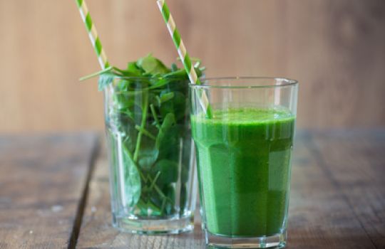 Zwei Gläser mit Strohhalm, eins mit Spinat gefüllt, eines mit einer grünen Flüssigkeit.