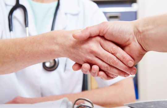Ein Arzt schüttelt einem Patienten die Hand.