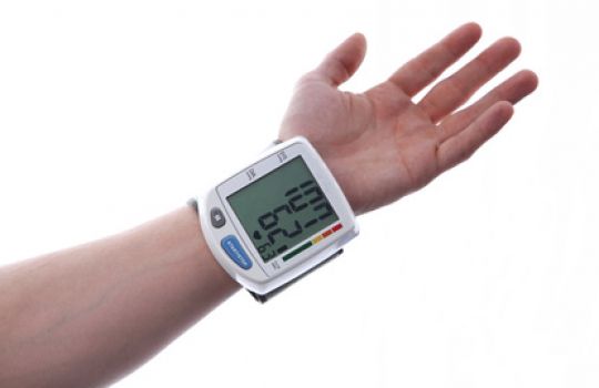 Blutdruckmessgerät am Handgelenk zeigt niedrigen Blutdruck an: 107/62 mmHG.